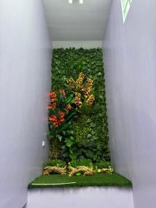 a room with a green wall with flowers and plants at Home Stay Hotel in Canelar
