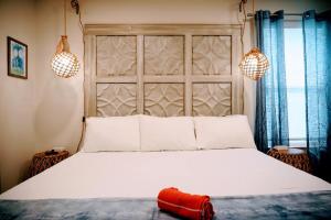 a bedroom with a large white bed with a red headboard at Anna Maria Island Tree House Pet Friendly! in Bradenton Beach