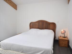une chambre avec un lit blanc avec une tête de lit en bois dans l'établissement Cottage in Mirabel near Chauvet Cave, à Mirabel 31 autres photos