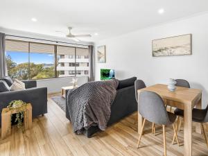 a living room with a couch and a table at Beachside Views 2 Bedroom Apartments Mooloolaba in Mooloolaba