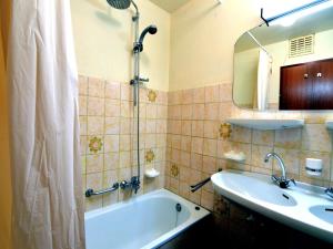 ein Badezimmer mit Badewanne, Waschbecken und Spiegel in der Unterkunft Cozy Forest Chalet in Ovifat in Ovifat + 31 Fotos