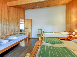 Habitación con 4 camas y paredes de madera. en Nature retreat for families, en Lignières