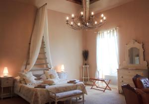 a bedroom with a bed and a chandelier at Les Carmes and spa in Le Thor