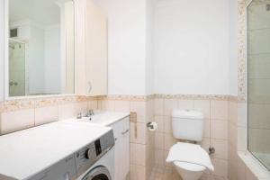 a bathroom with a sink and a washing machine at 806 Deluxe Delight Concert Hall Studio in Perth