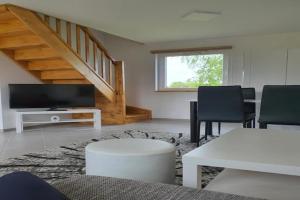 a living room with a television and a table and chairs at Comfortable holiday home, sauna, fishing pond in Wodnica