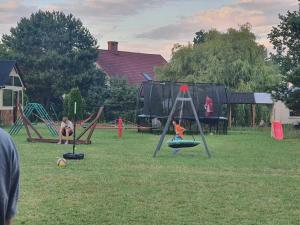 a group of children playing on a playground at Comfortable holiday home, sauna, fishing pond in Wodnica +22 photos
