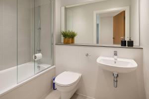 a bathroom with a toilet and a sink and a mirror at Landvue Stays, Modern, 2 bed apartment with free parking! in Coventry +18 photos