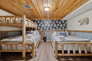 2 letti a castello in una camera con soffitto in legno di Riverfront Log Cabin Hot Tub, Mtn Views & Hottub a Maurertown