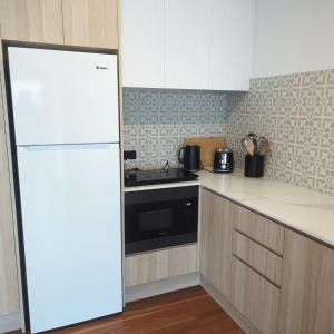 a kitchen with a white refrigerator and a stove at R n R Yamba in Yamba +12 photos
