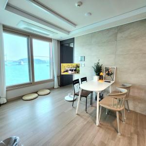 ein Esszimmer mit Tisch und Stühlen und einem großen Fenster in der Unterkunft Busan #Gwanganri #Full Ocean #Healing in Busan