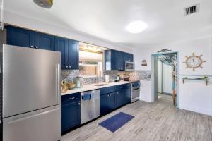 a kitchen with blue cabinets and a stainless steel refrigerator at Treasure home in St-Pete Beach in St. Pete Beach
