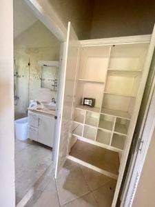 a bathroom with white shelves and a sink at Villa Española in Sosúa