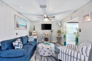 a living room with a blue couch and a tv at Treasure home in St-Pete Beach in St. Pete Beach