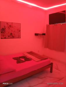 een rode kamer met een bed met een rood gordijn bij Pousada suite Praia in Mangaratiba