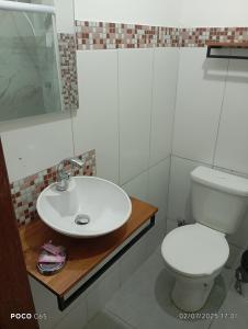 マンガラチバにあるPousada suite Praiaの白い洗面台とトイレのあるバスルーム