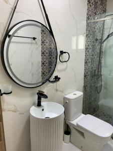 a bathroom with a sink and a mirror and a toilet at Appartement confortable à mdiq in M'diq +5 photos