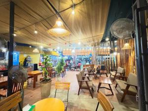 un restaurant avec des tables et des chaises en bois et une salle avec des tables dans l'établissement Cao Nguyên Bungalow, à Duong Dong