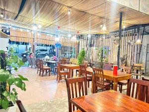 un restaurant avec des tables en bois, des chaises et des tables en bois dans l'établissement Cao Nguyên Bungalow, à Duong Dong