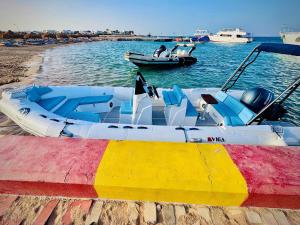 two boats are docked on the water near a beach at Wave Dancer in Hurghada