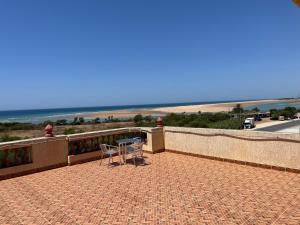 two chairs and a table on a balcony overlooking the beach at Penthouse Armonía in Briech
