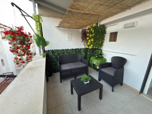 a patio with chairs and a table and flowers at Chill House da Nico in Castellana Grotte
