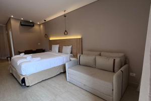 a hotel room with a bed and a couch at Chalé para 4 pessoas in Campina Grande do Sul