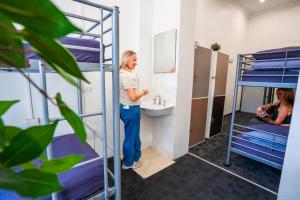 a woman standing in a room with bunk beds at Mad Monkey East Side in Sydney