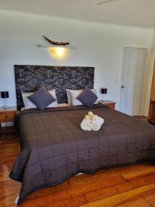 a bedroom with a large bed with two towels at Ocean Beach Bach Rarotonga in Rarotonga