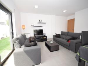 Una sala de estar con dos sofás y un televisor. en Holiday Home Nazaré Beach for Surfing, en Famalicão