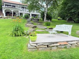 a bench sitting on a wooden platform in a yard at The Manor-Stunning Modern Farmhouse with Hot Tub in Dover