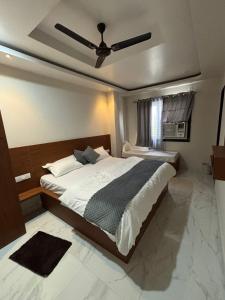 a bedroom with a large bed with a ceiling fan at Hotel Shri Ram Gopal Seva Dham in Vrindāvan