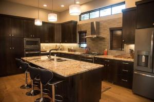 a kitchen with a large island with bar stools at Gleneagles Golf Course Retreat With Hot Tub in Columbia Falls