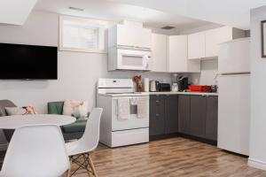 a kitchen with white appliances and a table with chairs at 1 Bedroom Studio Close To University Of Guelph in Guelph +8 photos