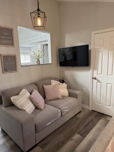 a living room with a couch and a mirror at The Stuffed Quahog - Perfect Location Near Beach in Hampton