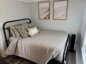 Una cama en un dormitorio con dos cuadros en la pared. en The Lighthouse - Perfect Location Near Beach, en Hampton