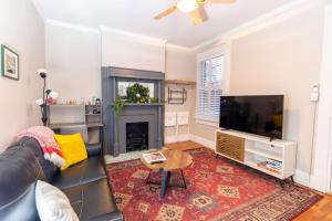 a living room with a couch and a television at Walkable and Cozy German Village HausPets OK in Columbus