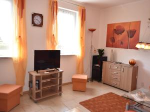 d'un salon avec une télévision à écran plat et une commode. dans l'établissement Boiensdorf Beachside Bungalow, à Boiensdorf