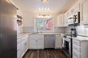 a kitchen with white cabinets and stainless steel appliances at Historic Boho Brothel Lake Retreat Fast Wifi in Twin Lakes +36 photos