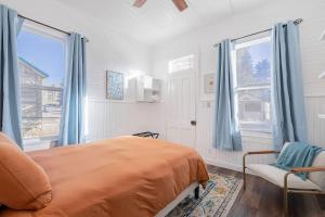 a bedroom with a bed and a chair and windows at Historic Boho Brothel Lake Retreat Fast Wifi in Twin Lakes