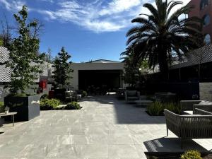 サンティアゴにあるApartamento Exclusivo con las Mejores Vistas de la Ciudad en un Edificio de Lujoのヤシの木と建物のあるパティオ