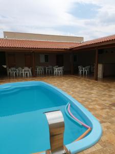 - une piscine en face d'un bâtiment avec des chaises dans l'établissement Casa de festa, à Barretos
