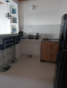 a kitchen with a refrigerator and a counter top at Apartamento comodo in Cali