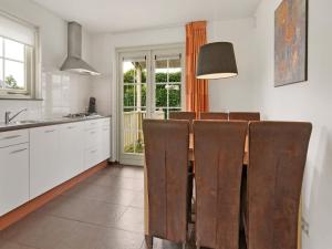 a kitchen with a dining room table and chairs at Bungalow by Water with Sauna in South Holland in Simonshaven