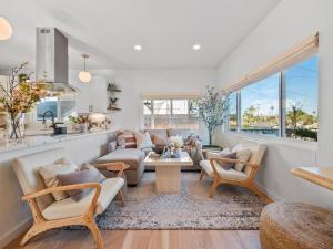 - un salon avec de nombreux meubles et fenêtres dans l'établissement Luxe OB Home, Walk to Beach, Sauna, and Backyard, à San Diego