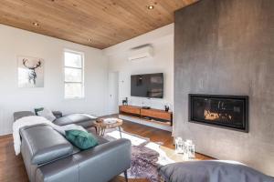 ein Wohnzimmer mit Couch und Kamin in der Unterkunft Chalet Xo Tremblant - 5brs, Private Baths, Spa, Sauna & Rooftop in La Conception