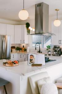 Luxe OB Home, Walk to Beach, Sauna, and Backyard في سان دييغو: مطبخ بخزائن بيضاء وطاولة عمل