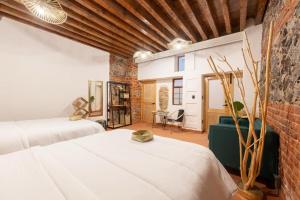 a bedroom with two beds and a brick wall at DH3 VIP & Luxurious 2beds APT in Historic Center in Mexico City
