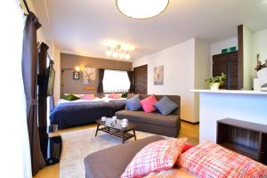 a living room with a couch and a living room with at Alphabed広島平和大通り in Hiroshima