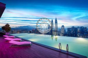 a swimming pool with pink chairs and a city skyline at HOME STYLE at Platinum Suites KLCC Twin Towers in Kuala Lumpur