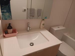 a white bathroom with a sink and a toilet at New condo Great amenities Near Skytrain in Coquitlam +27 photos